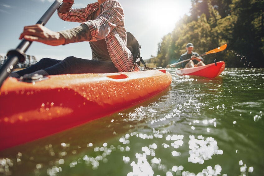 Kayakers on a river to demonstrate buying the right kayak Kayakers on a river to demonstrate buying the right kayak