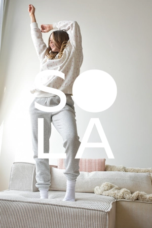 <div class="sola-bar">
    Sola <span>›</span>
</div>

<style>
.sola-bar {
    text-align: center;
    background: #E8C9C5;
    color: #302E2D;
    font-weight: 700;
    font-size: 16px;
    padding: 12px 14px;
    margin-top: 0;
    cursor: pointer;
    border-bottom: 4px solid #C99E91;
    transition: all .2s ease;
}

.sola-bar:hover {
    filter: brightness(90%);
}

.sola-bar span {
    display: inline-block;
    margin-left: 7px;
    font-size: 20px;
    line-height: 1;
    transition: transform .2s ease;
}

.sola-bar:hover span {
    transform: translateX(4px);
}
</style>